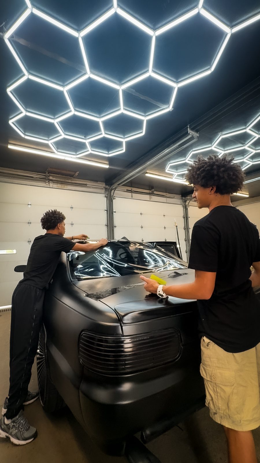 Installing a gloss wrap on a hood under hex lighting