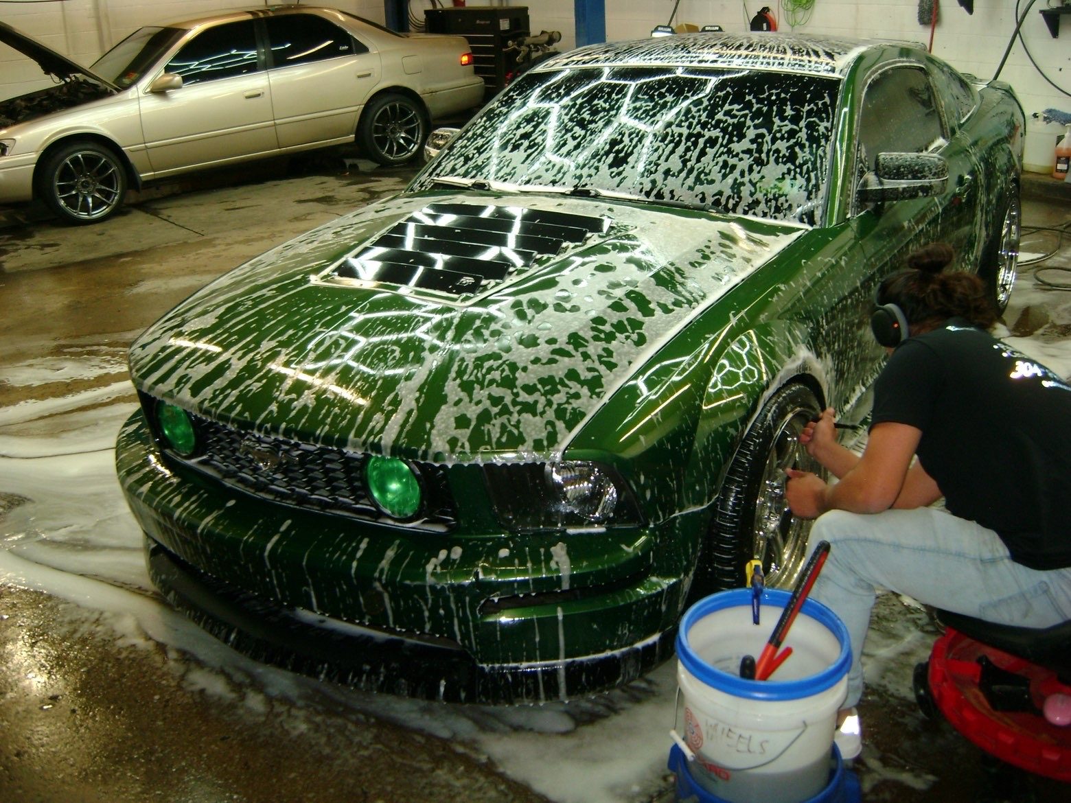 Green Ford Mustang GT covered in foam during a wash